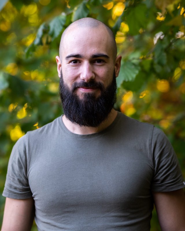 Porträt von Alessandro vor grünem Laub