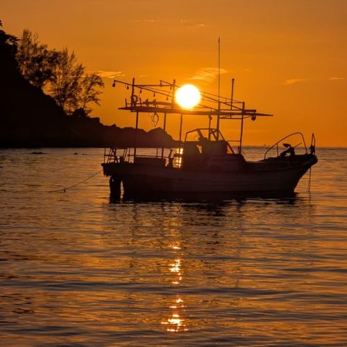 Fischerboot im Sonnenuntergang vor der Küste